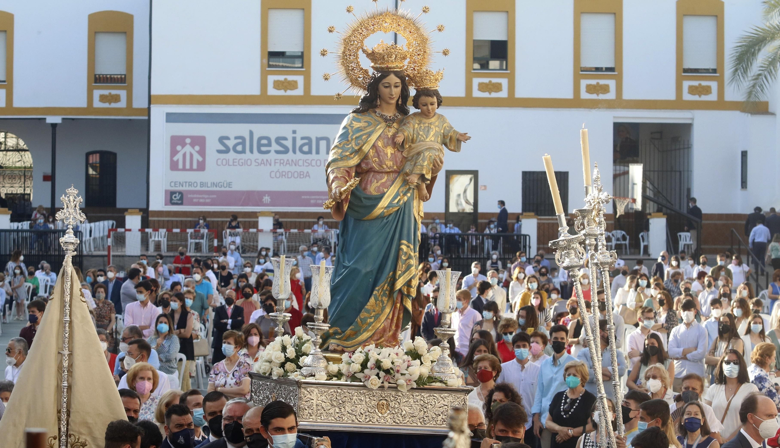 María Auxiliadora, portada en andas por sus hermanos, transita por el patio del colegio.