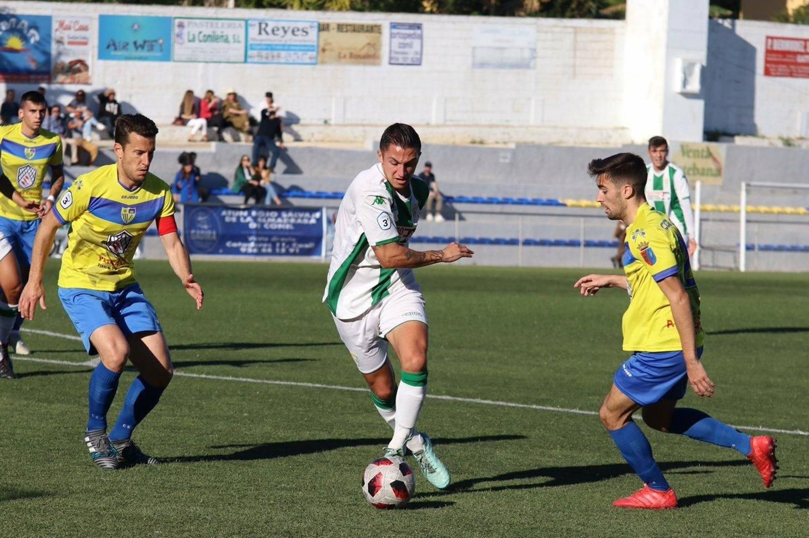 Un jugador del Córdoba B sale con el balón entre dos jugadores del Conil. Un jugador del Córdoba B sale con el balón entre dos jugadores del Conil.