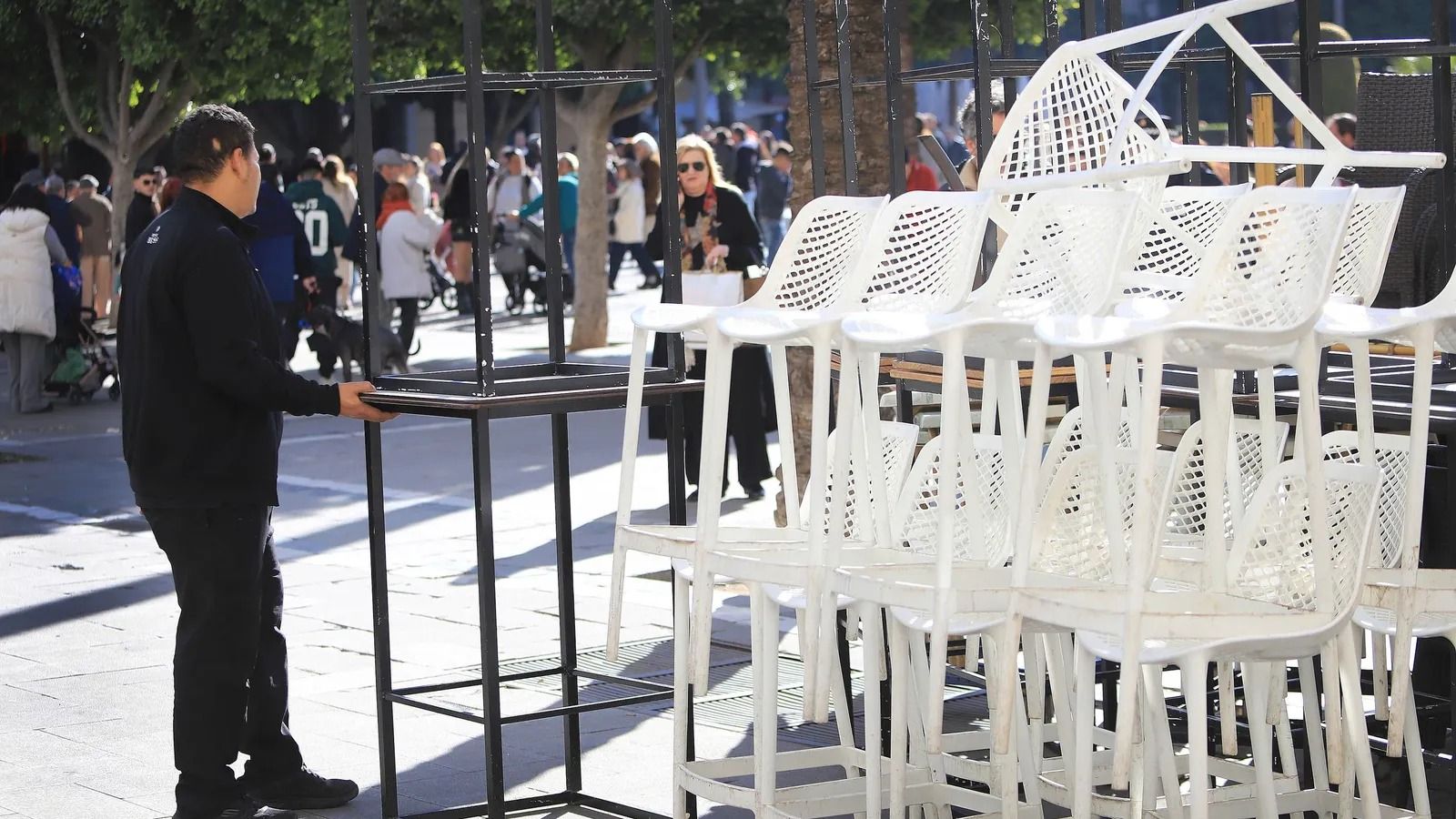 Un camarro monta la terraza de un bar.