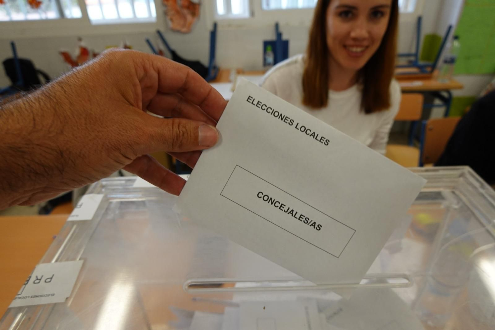 Una mujer, al fondo, esperando su turno en un colegio electoral para votar Una mujer, al fondo, esperando su turno en un colegio electoral para votar