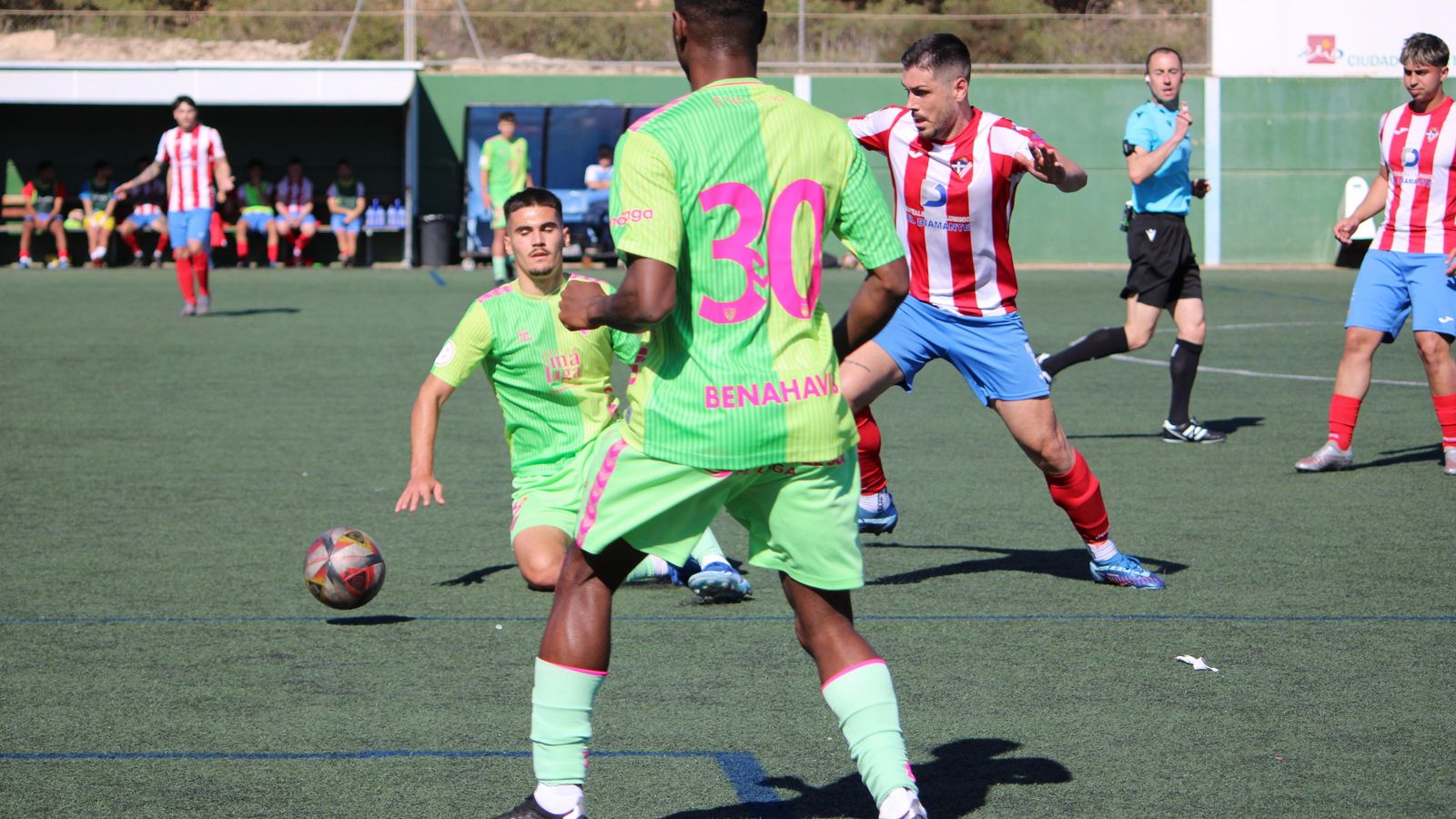 Un jugador local trata de irse de un futbolista del filial malagueño. Un jugador local trata de irse de un futbolista del filial malagueño.