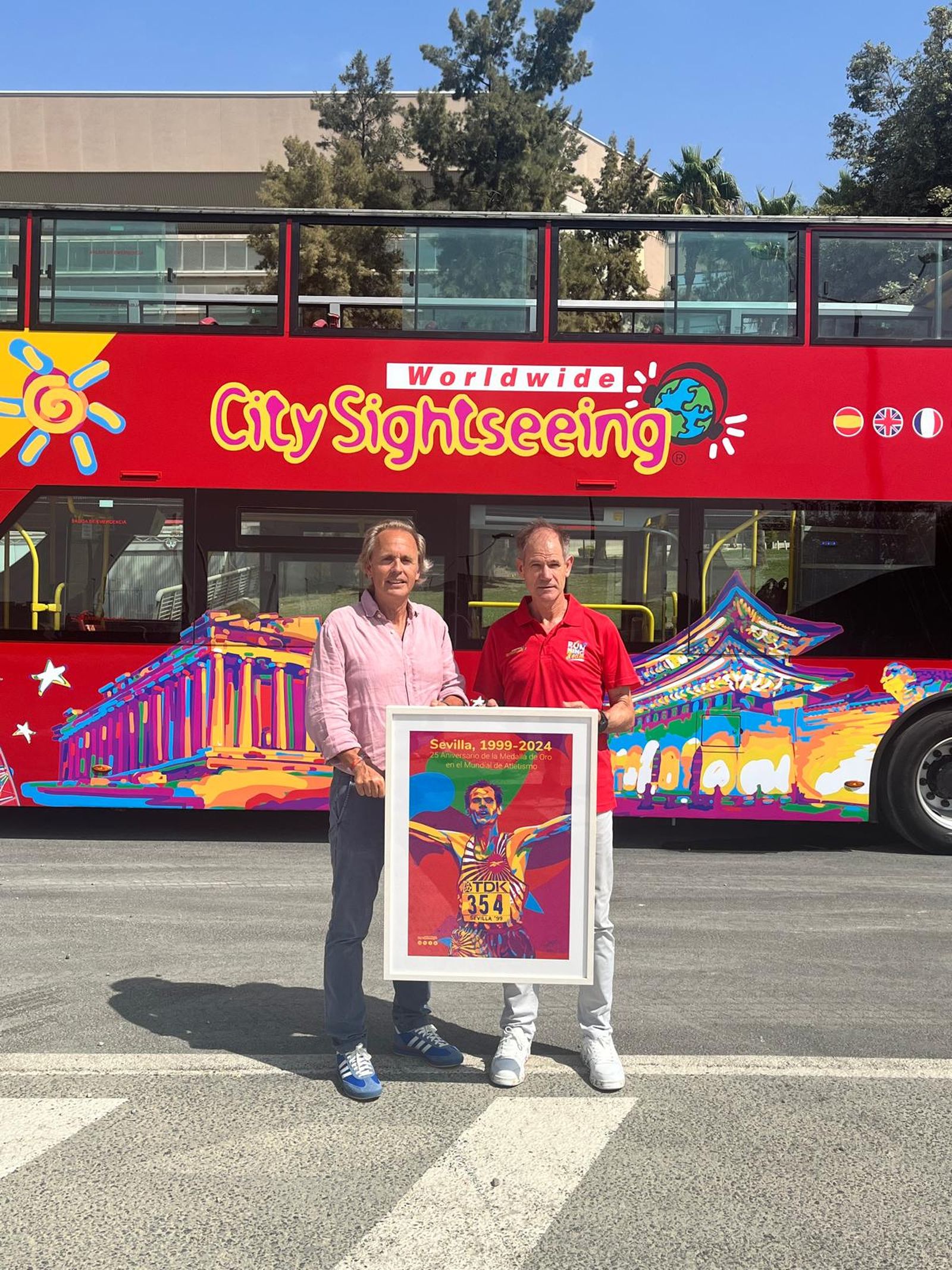 Abel Antón posa con Enrique Ybarra delante del autobús en el que hizo el recorrido de la maratón en la que ganó el oro mundial.