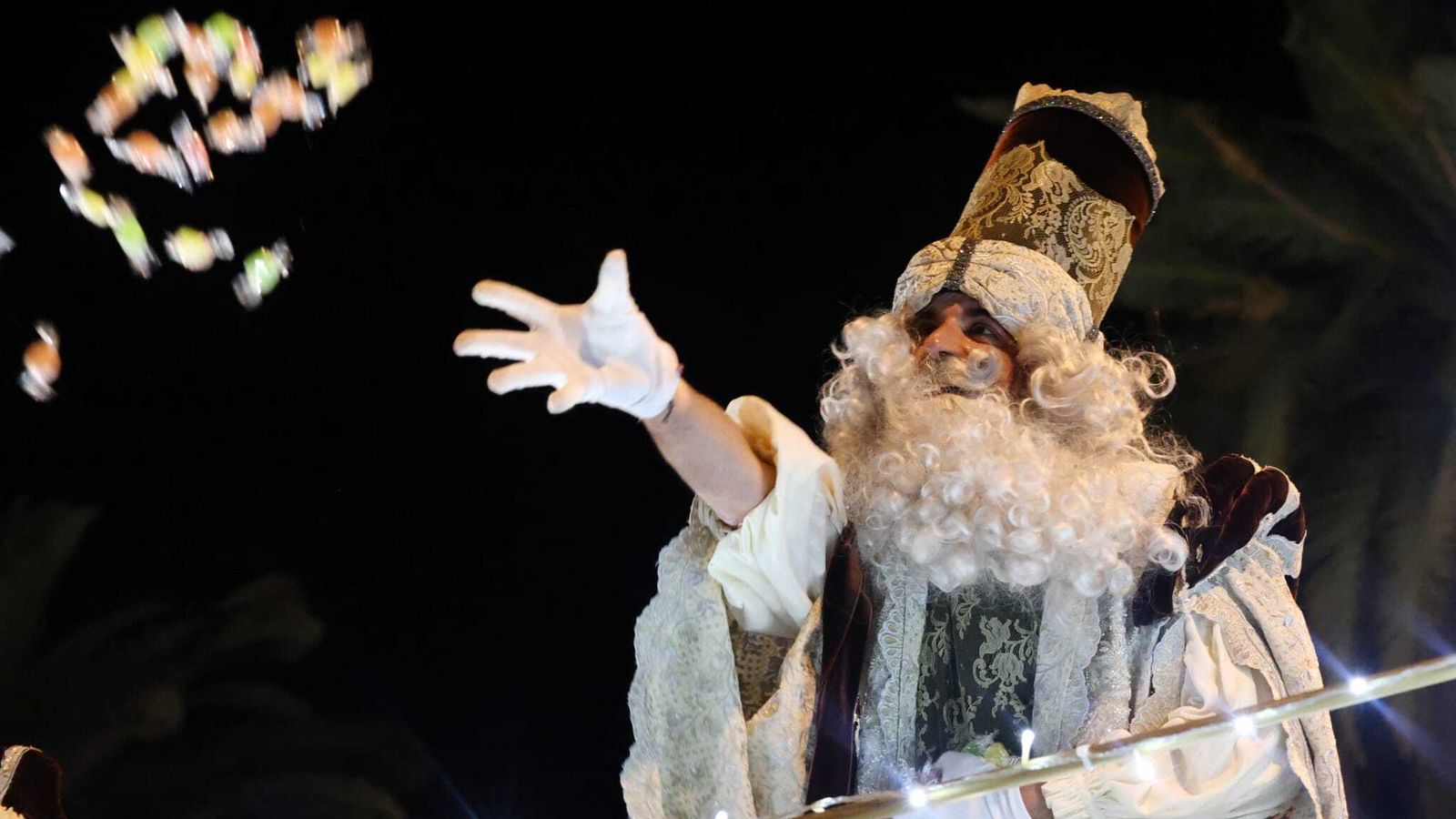 Melchor tira caramelos desde su carroza.