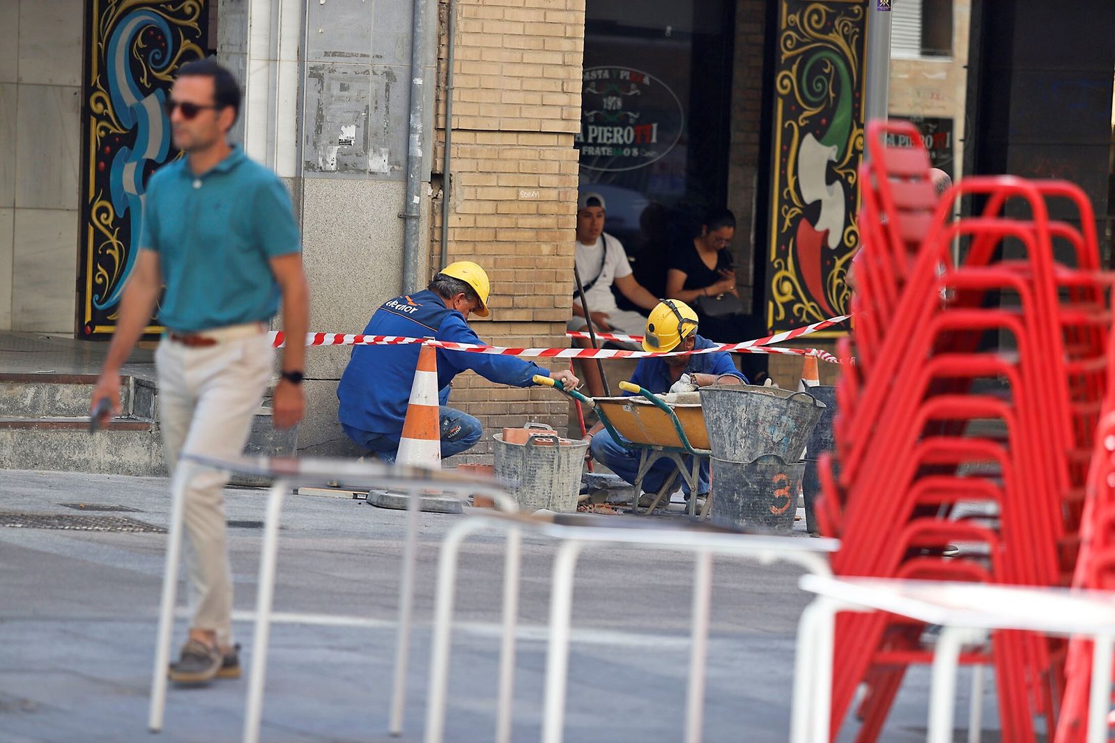 Dos operarios en una obra en el centro de Huelva, en pleno mes de julio.