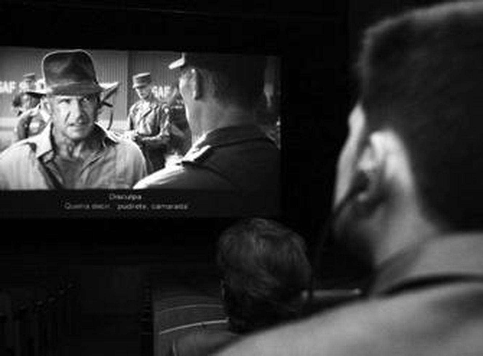 Una persona invidente sigue la película a través de las audiodescripciones de los auriculares.