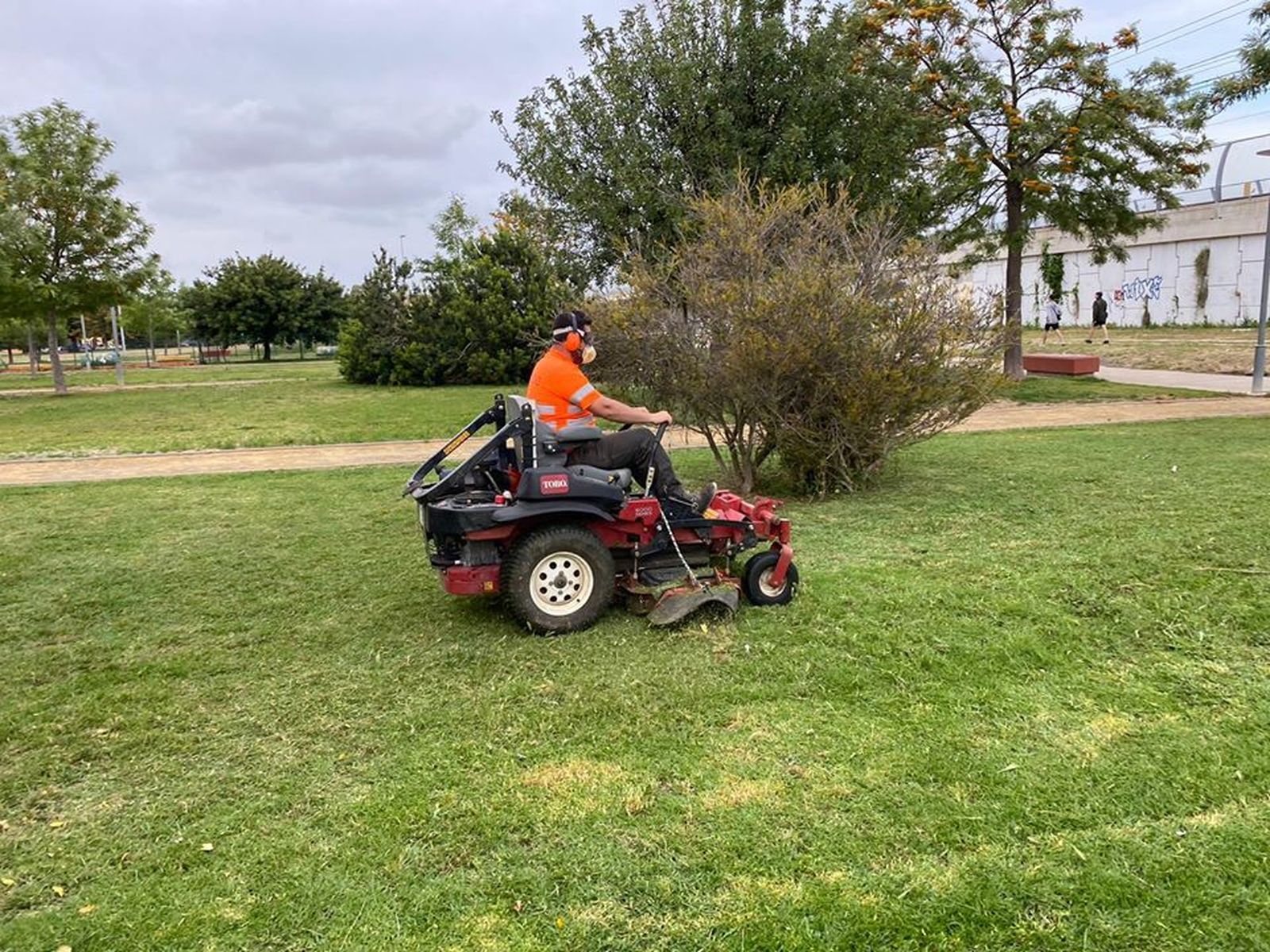 Un operario poda los jardines del Parque Atocha.