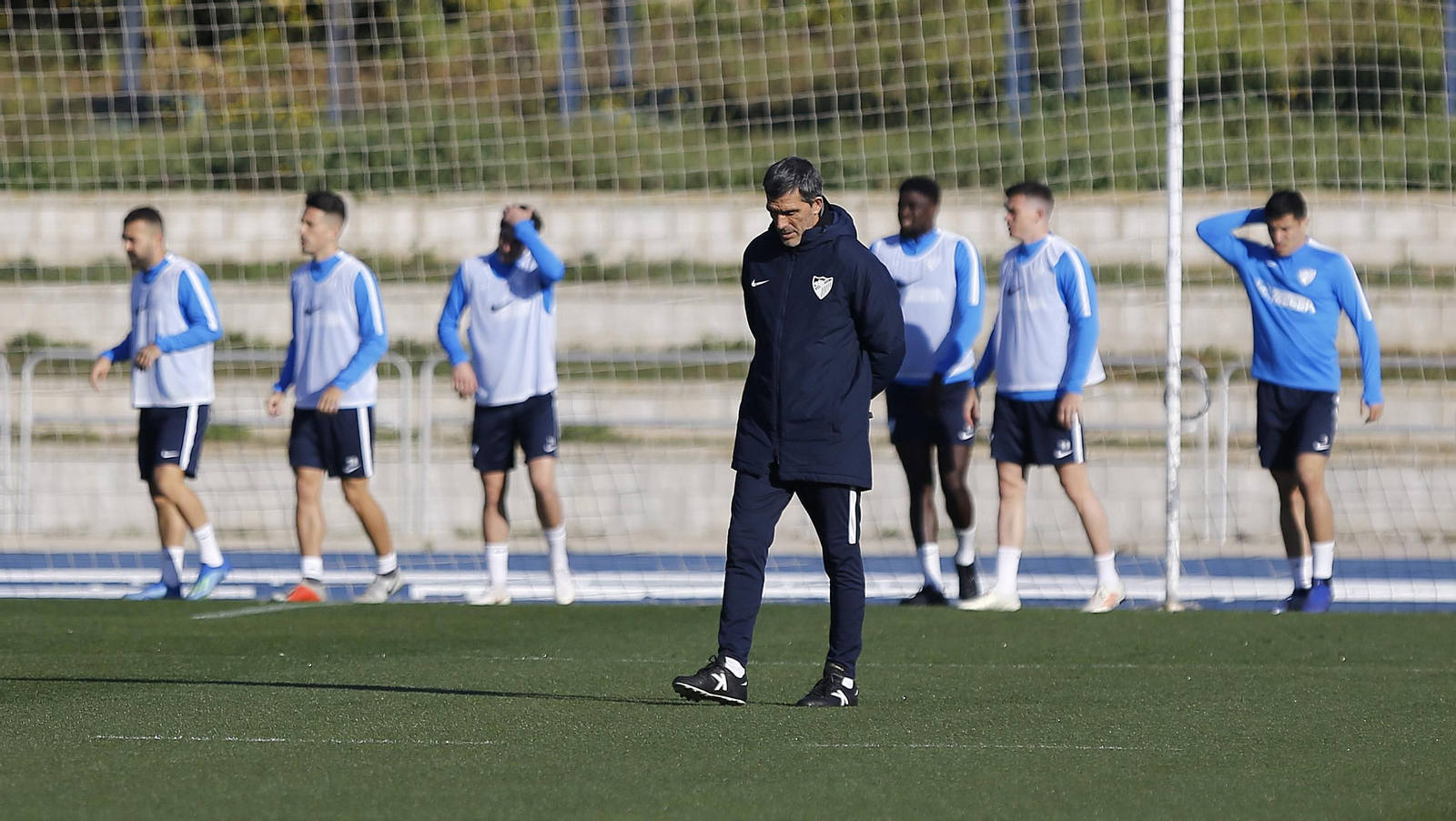 Muñiz, en un entrenamiento, con sus futbolistas al fondo.