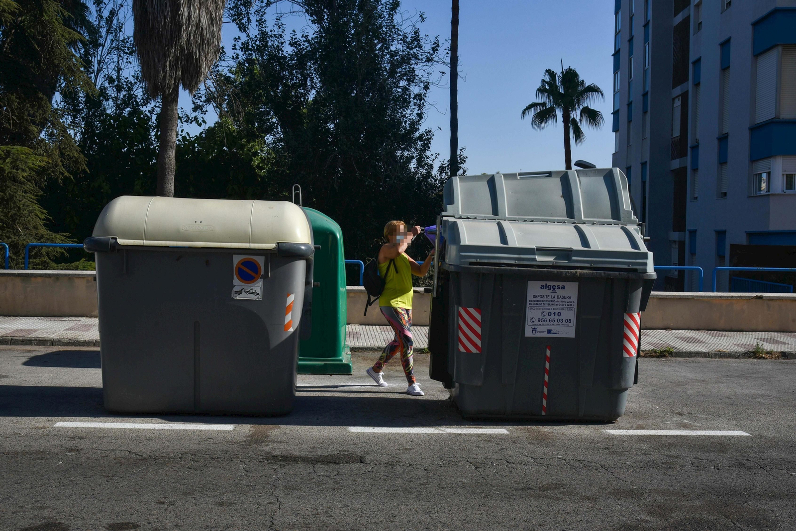 Una mujer tira la basura a un contenedor en Algeciras