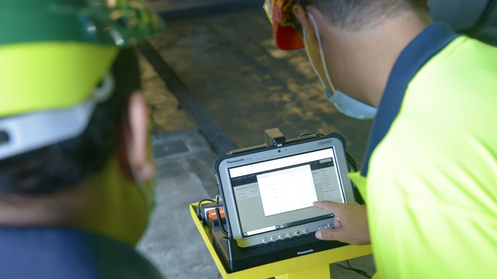 Dos trabajadores de Acerinox revisan la aplicación de los vehículos autónomos