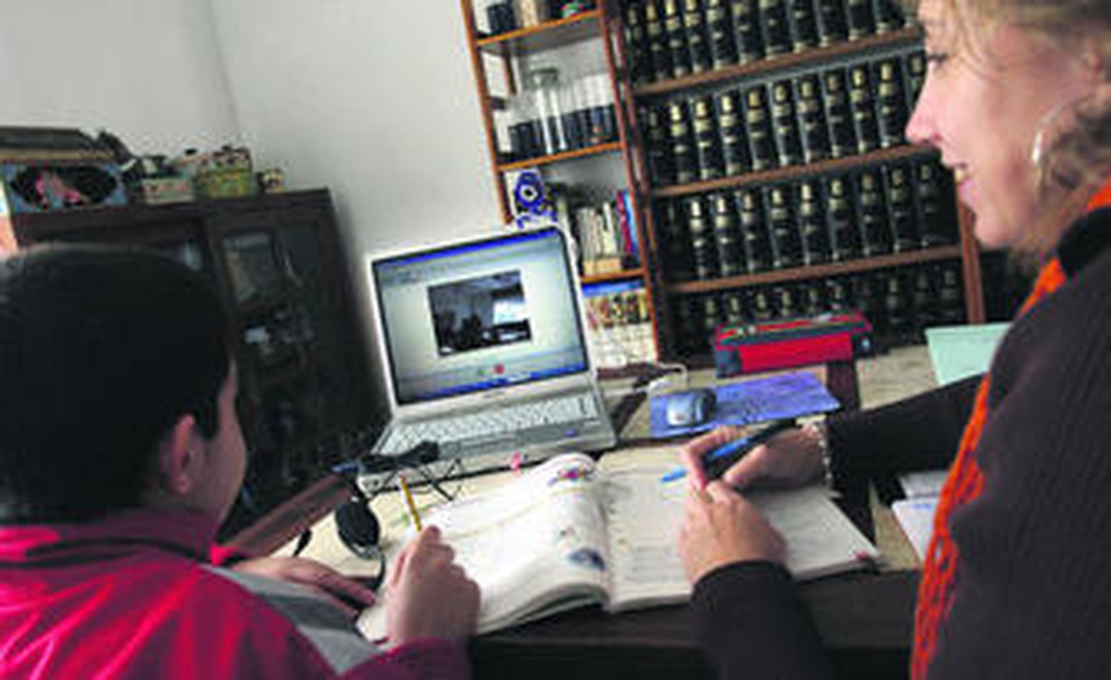 Un niño realiza los deberes con un portátil en su casa.