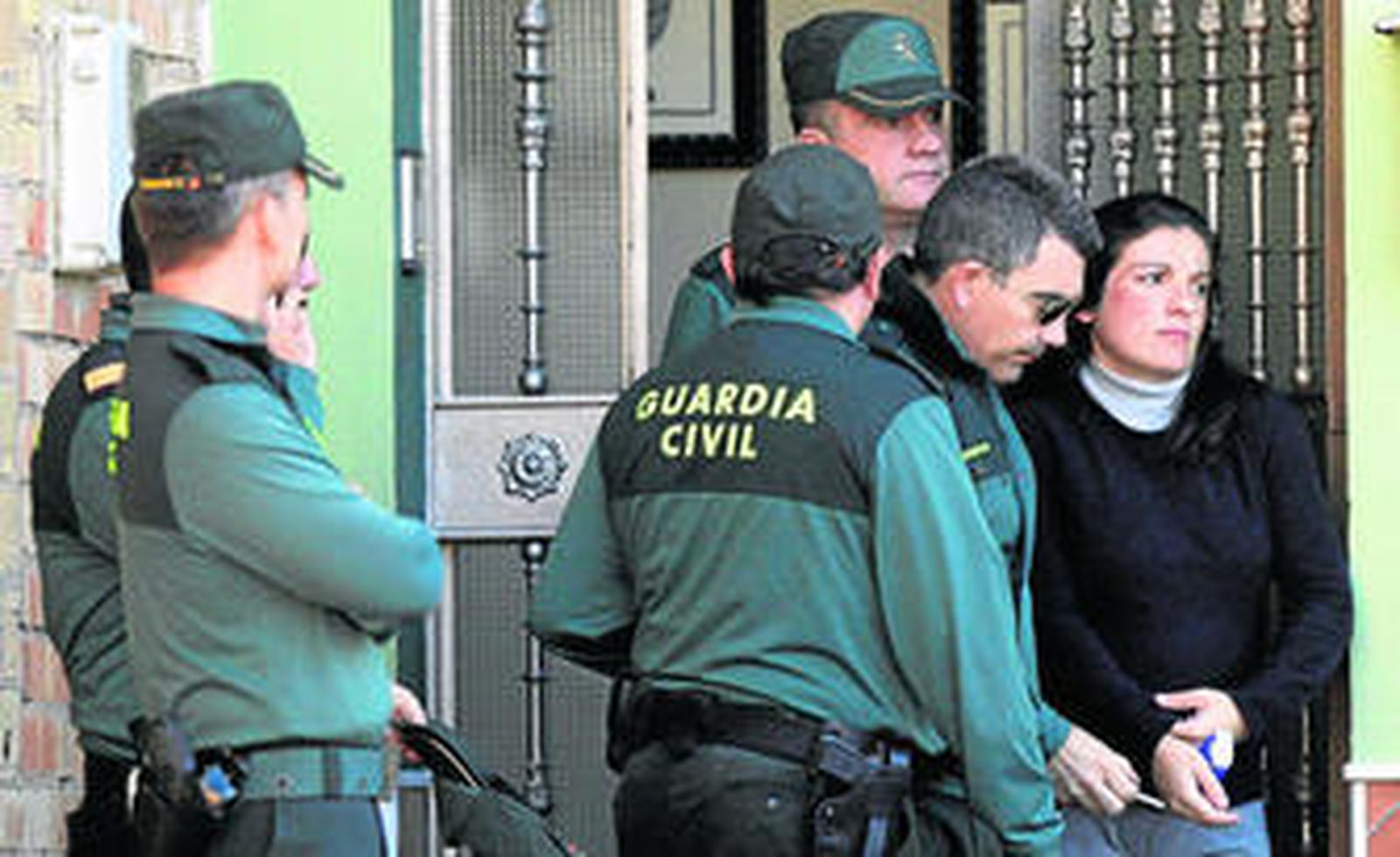 Varios guardias civiles acompañan a Sara López a la salida de la casa del registro