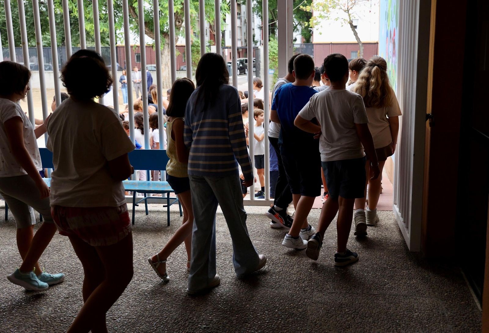 Un grupo de niños y niñas de diferentes edades en el interior de las instalaciones de un centro escolar en Sevilla.