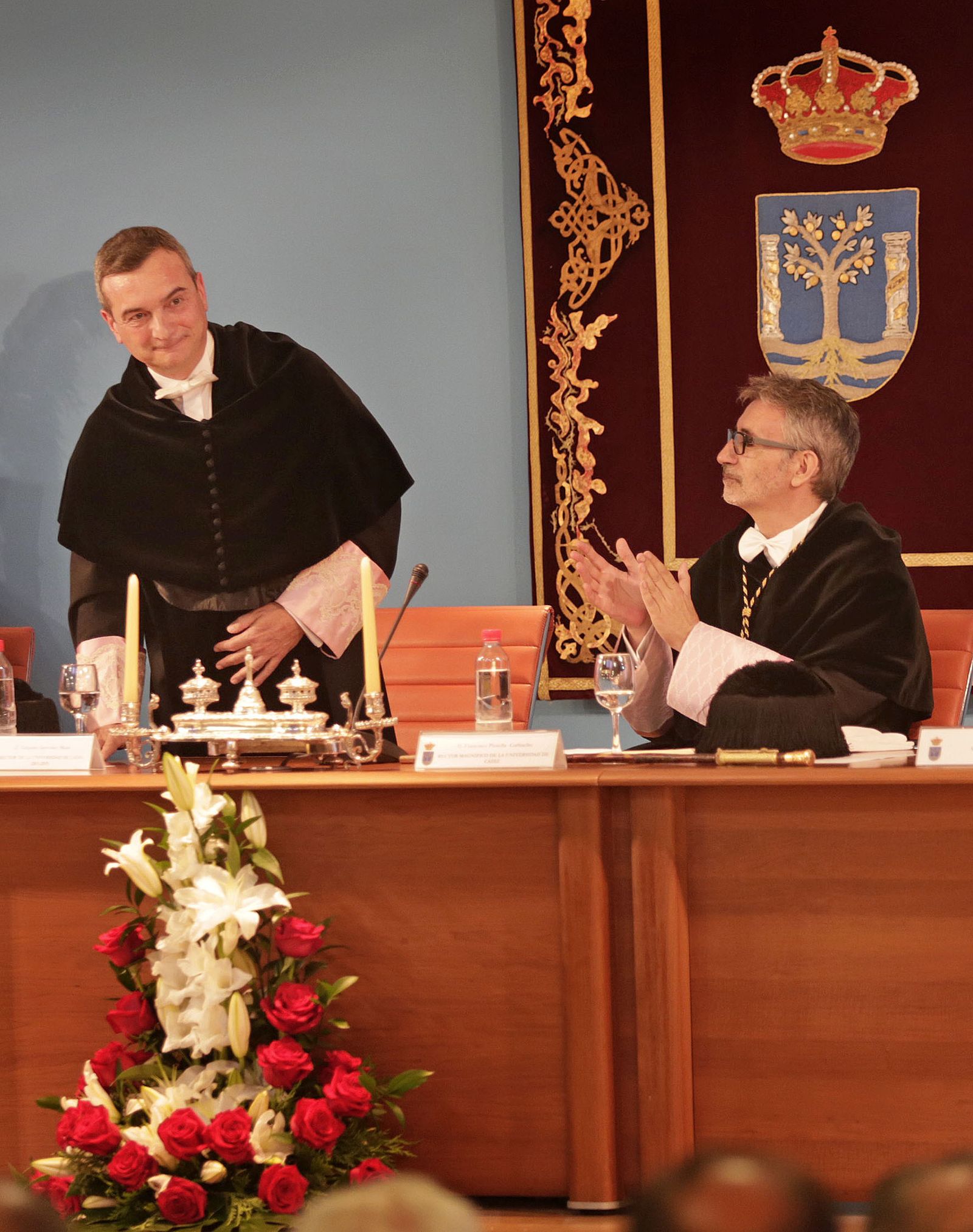 El rector entrante, Francisco Piniella, aplaude al saliente, Eduardo González Mazo.