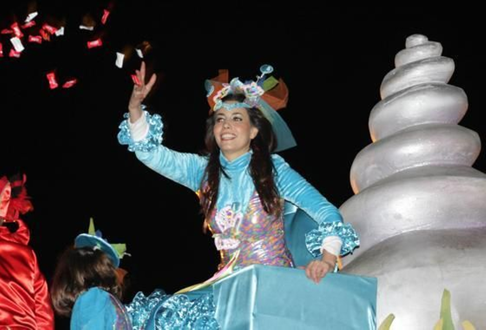 Una de las jóvenes de las carrozas lanza caramelos con ilusión.

Foto: Belén Vargas