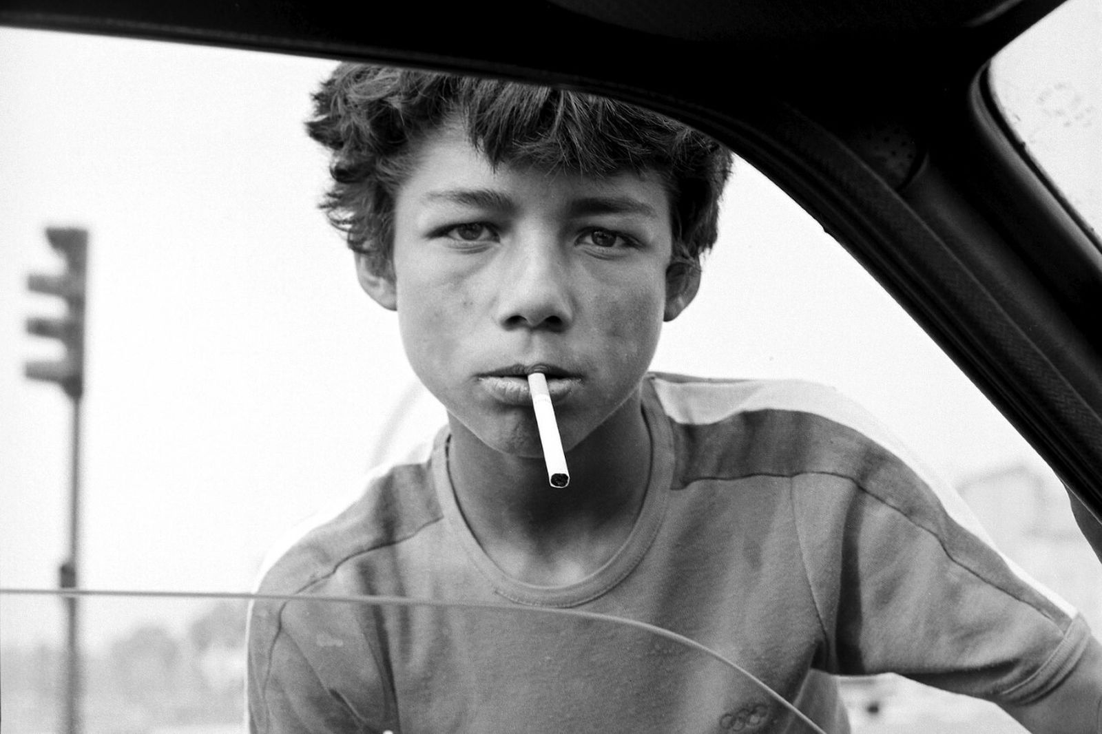 Un niño vende tabaco en un semáforo.