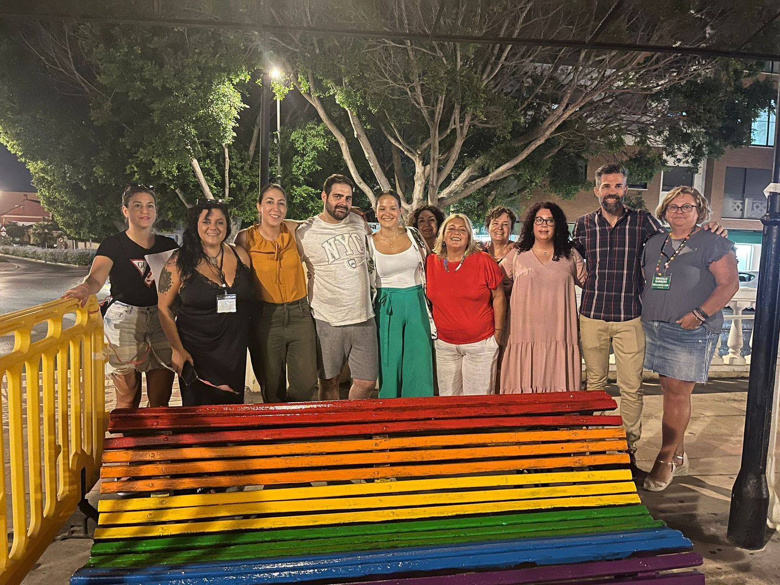 Los participantes en el pintado del banco arcoíris.