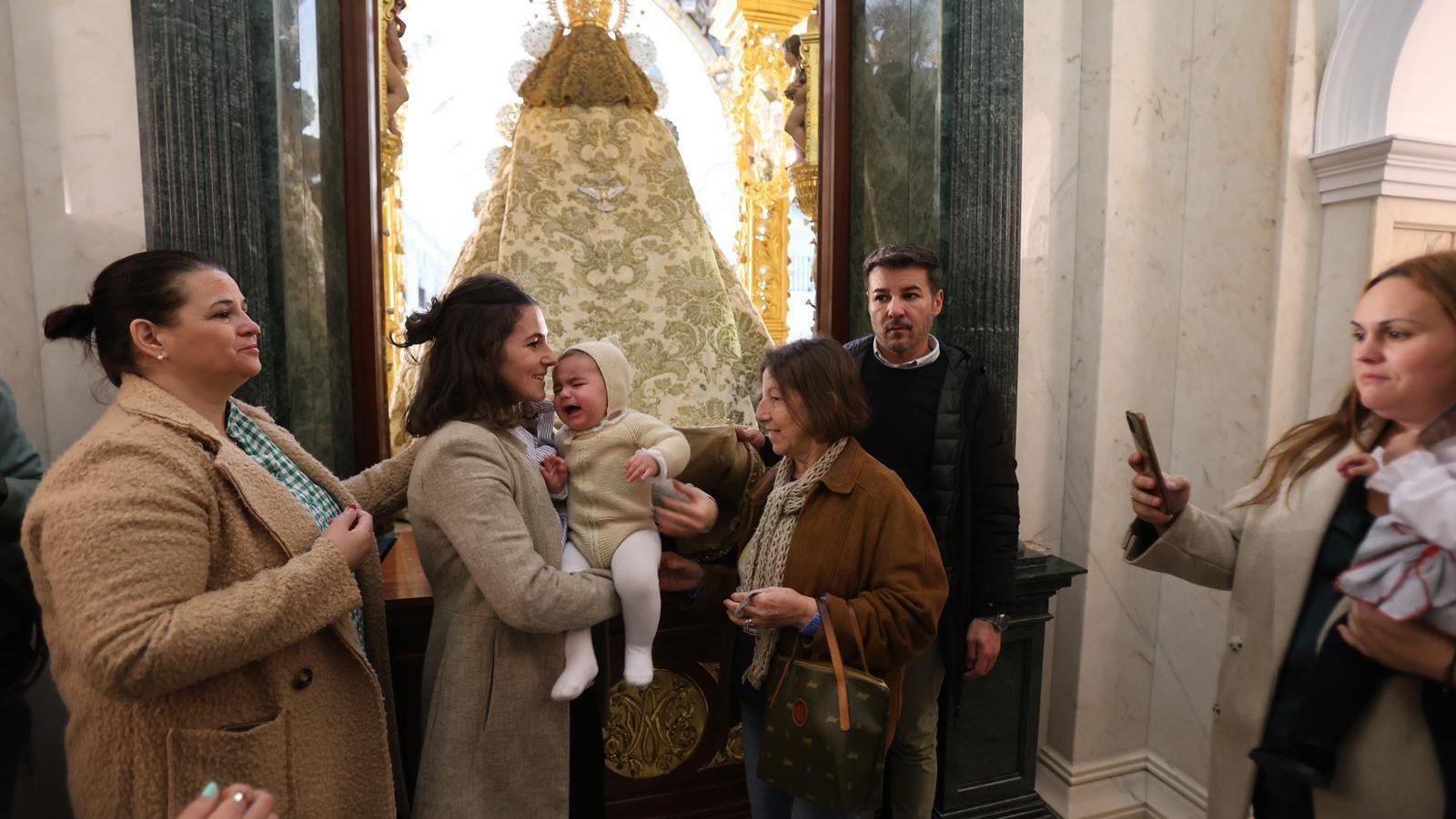 Pasan a un niño por debajo del manto de la Virgen.