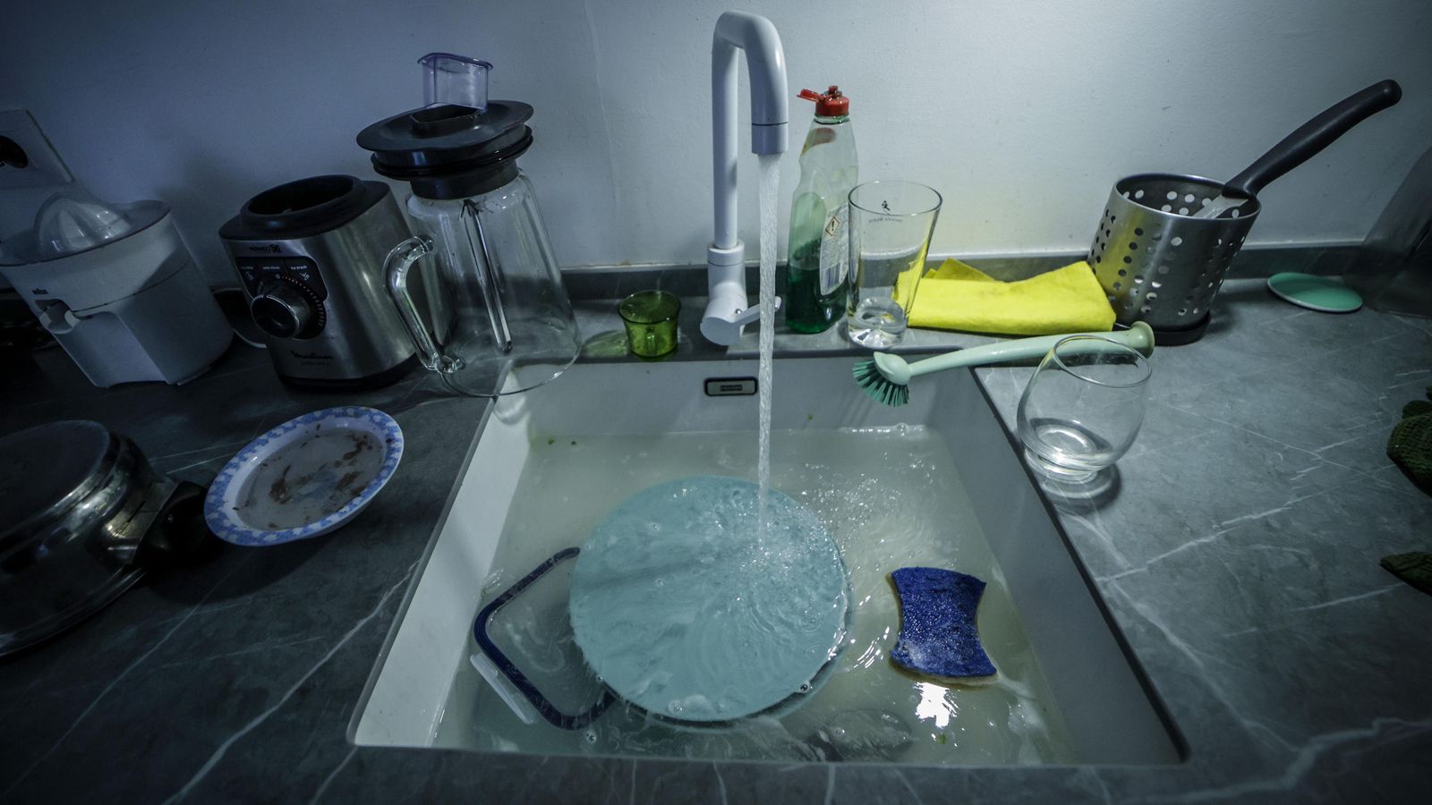 Un grifo abierto en el fregadero de una vivienda.