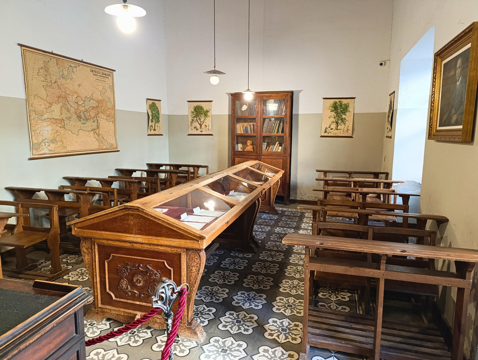 Bancadas y pupitres de madera que recrean fielmente la disposición del aula a comienzos del siglo XX, evocando la enseñanza de Machado.