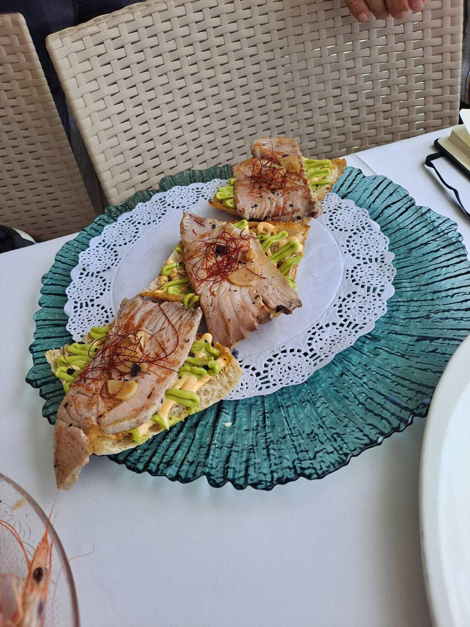 Atún a la plancha sobre base de aguacate.