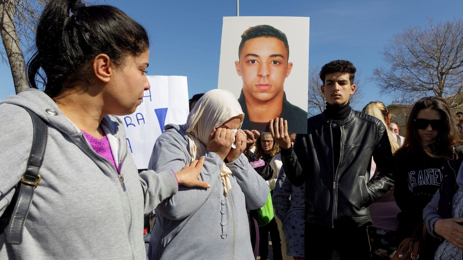 La madre de Reda llora delante de un retrato de su hijo durante una concentración tras el crimen.