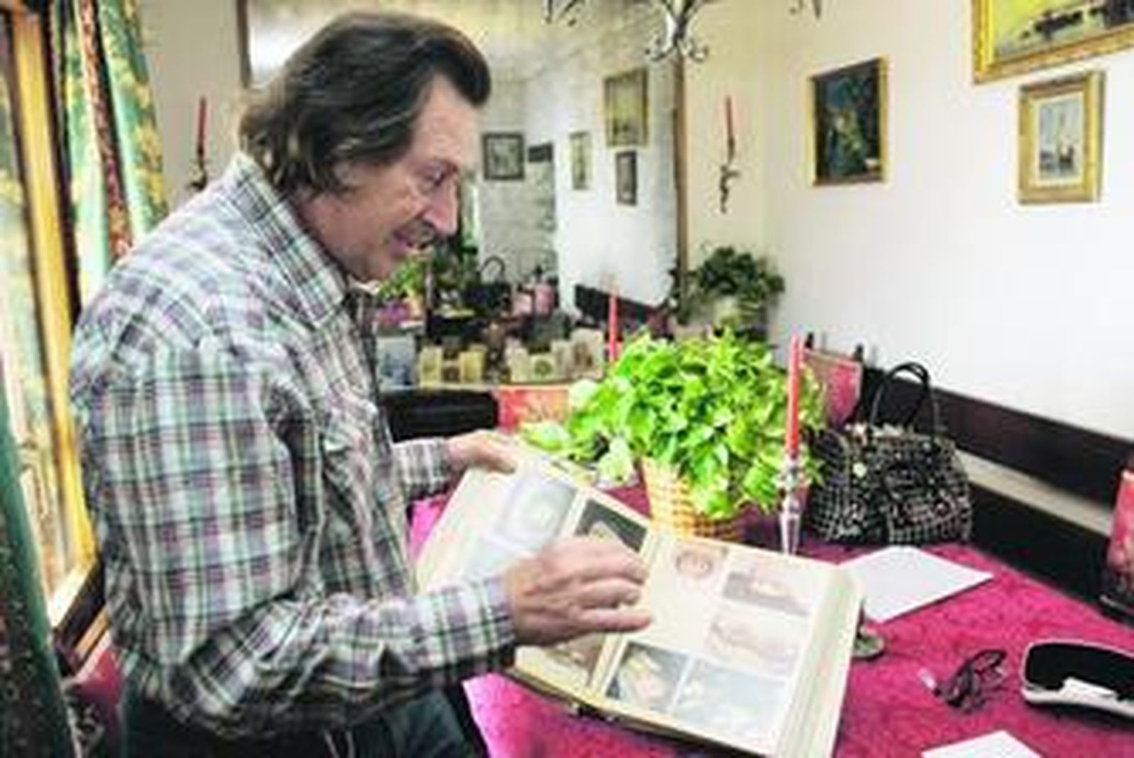 Thimbault muestra el álbum con fotos de algunos de los platos que elaboraba.