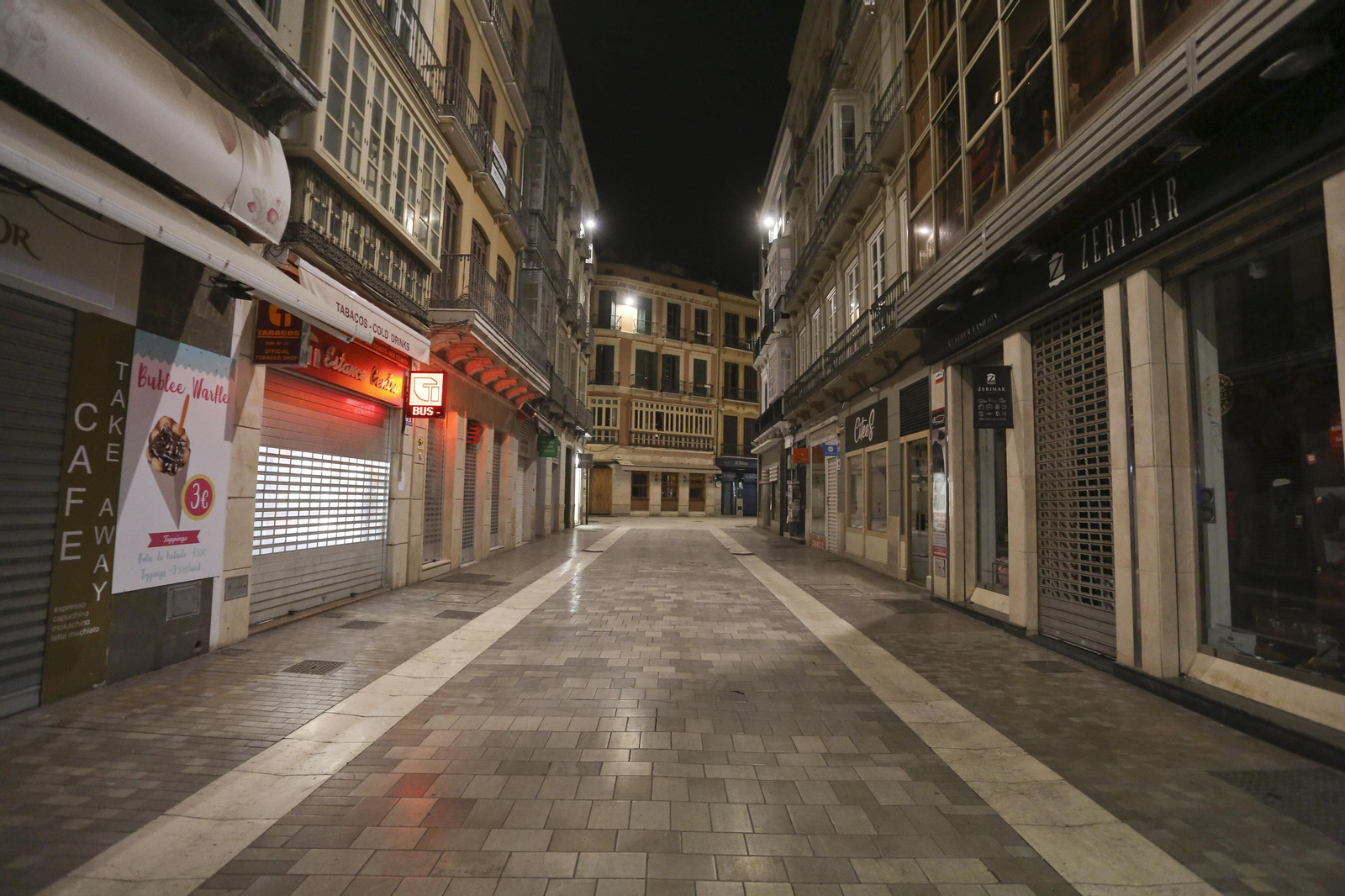 El coronavirus dibuja una noche desierta en el centro de Málaga, en fotos