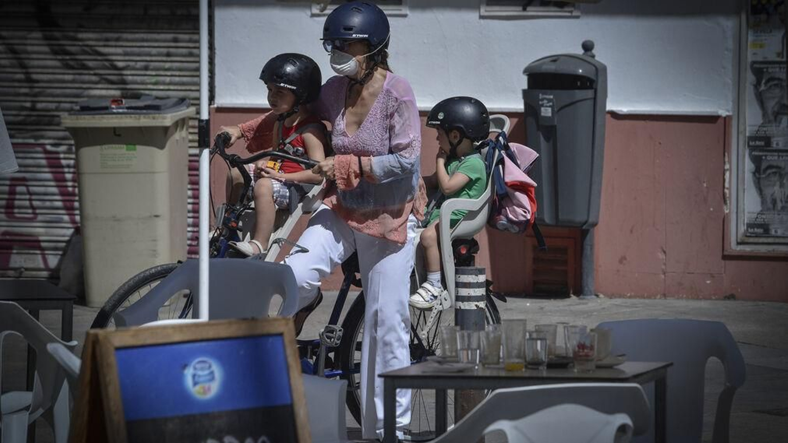 Una mujer con dos de sus hijos en una bicicleta.