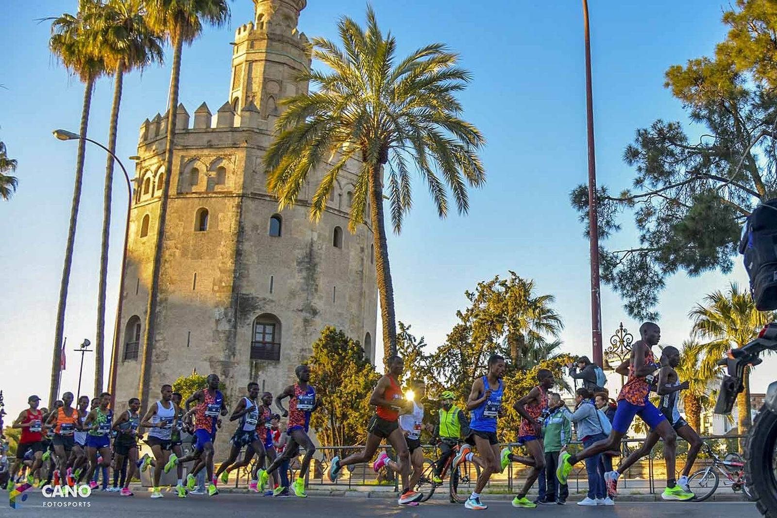 Atletas pasando por delante de la Torre del Oro.