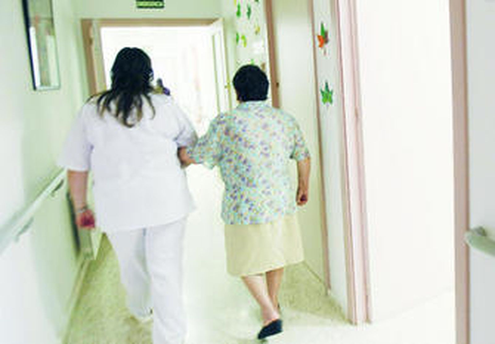 Una auxiliar ayuda a una persona mayor en un centro residencial de El Puerto de Santa María.