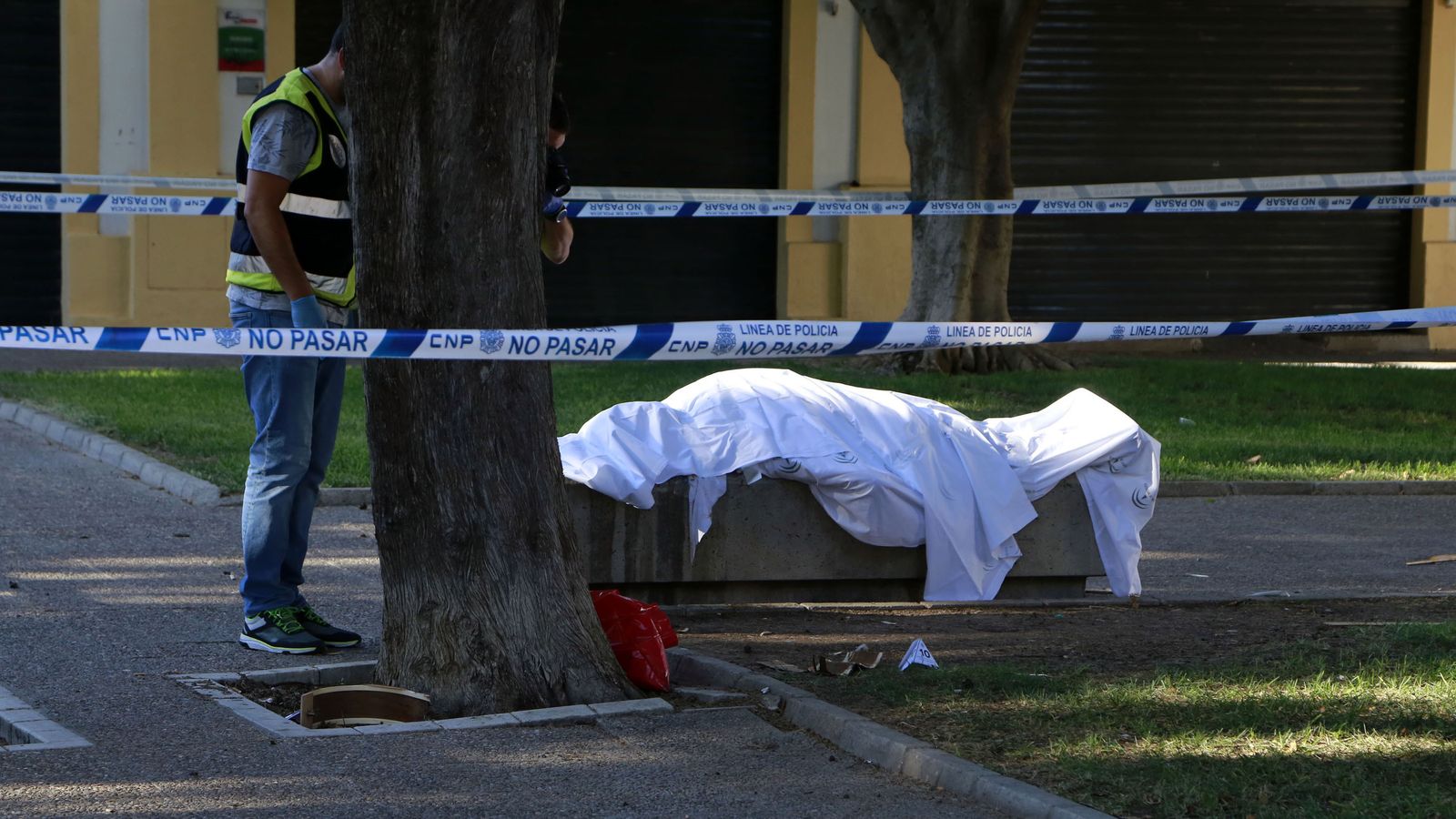 Agentes policiales custodian el cuerpo de la víctima minutos después del apuñalamiento.