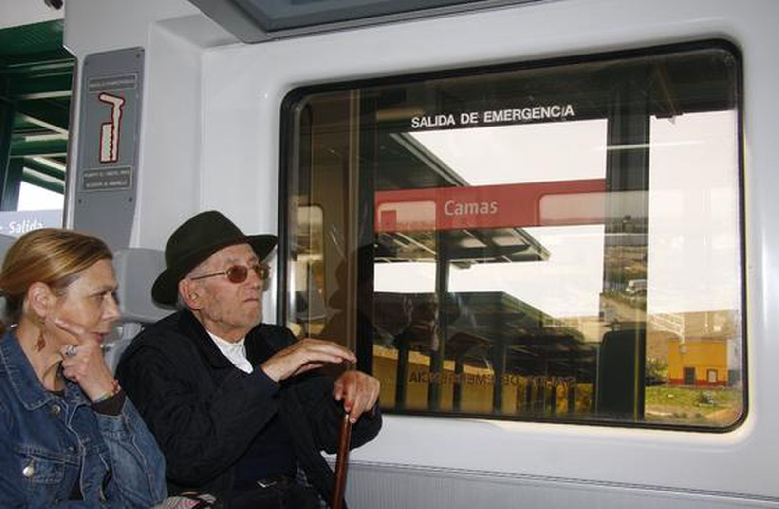 Dos viajeros dentro del tren a su paso por la estación de Camas.

Foto: B.Vargas