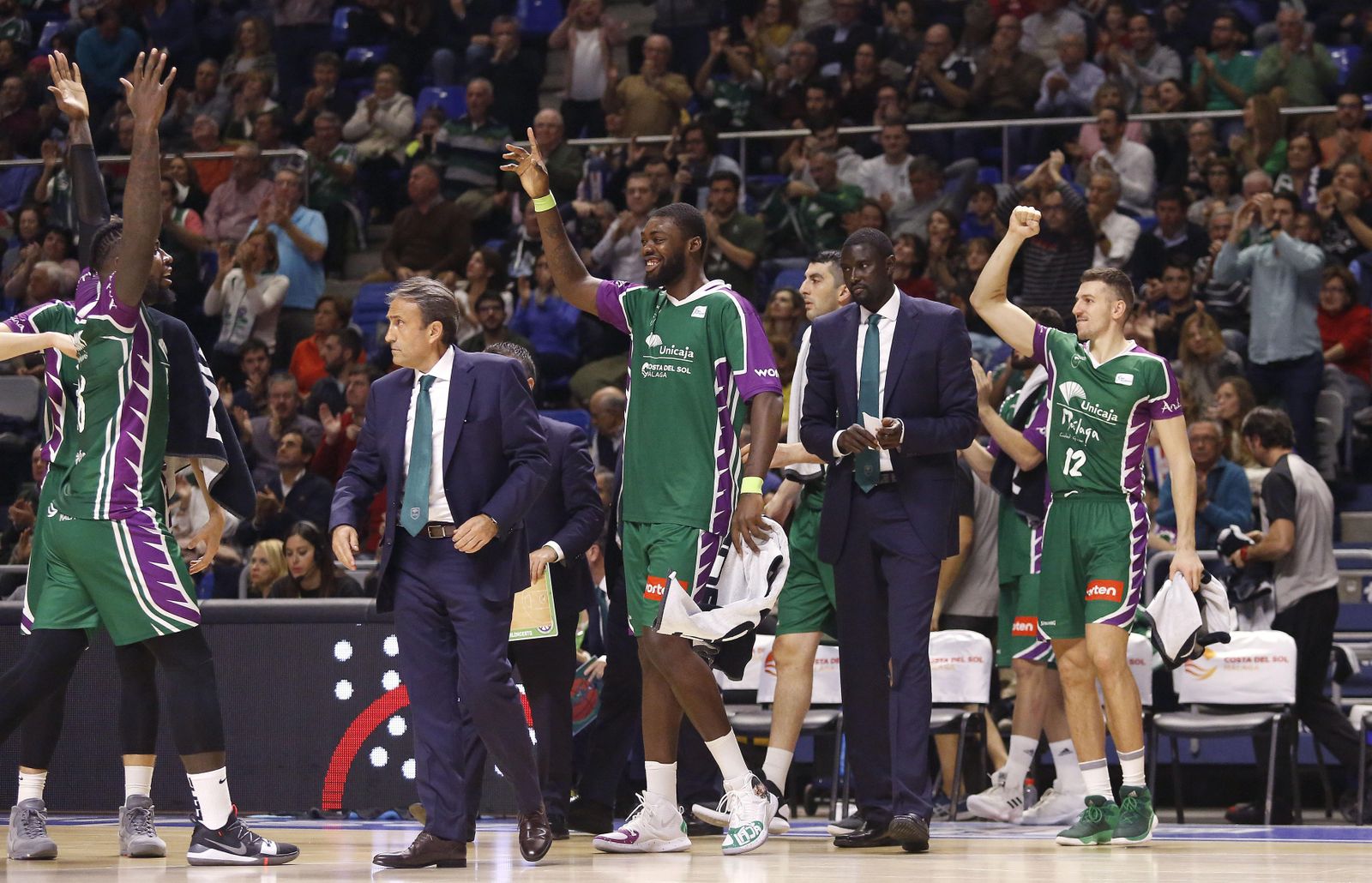 Los jugadores del Unicaja celebran, con Casimiro concentrado.