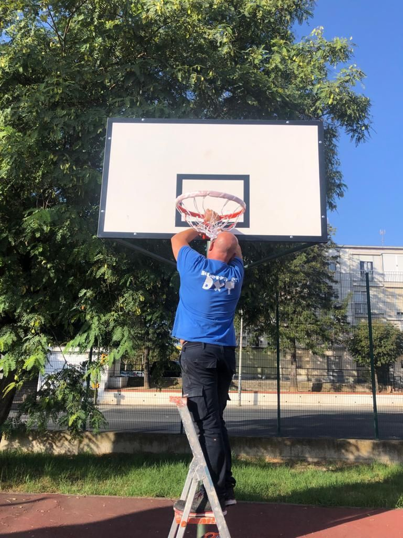 Colocación de red en una canasta de la calle Jabugo.