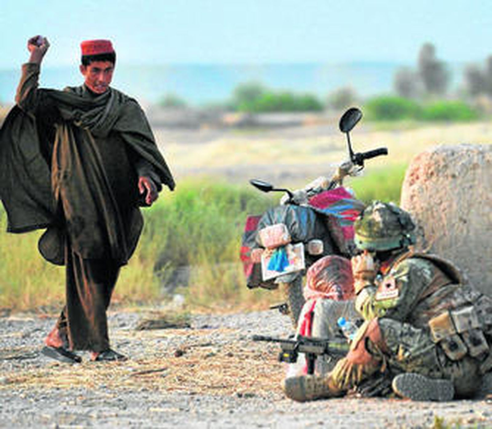 Un chico afgano tira una cebolla a un soldado en la localidad de Nahr-e-Saraj, en Helmand.