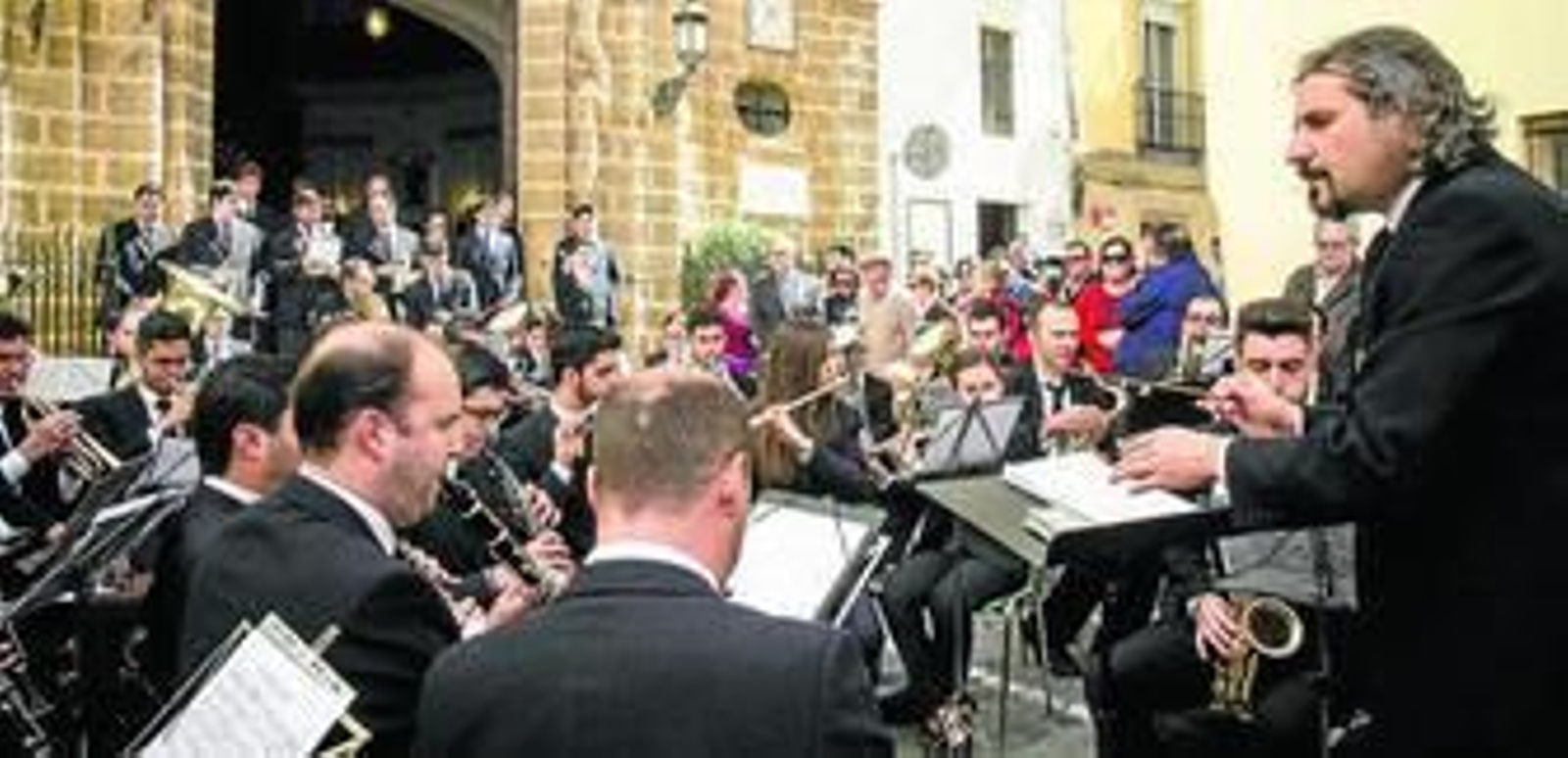 La banda de la Soledad de Cantillana, que intervendrá en el pregón de la Semana Santa de Cádiz 2014, tocando ayer ante la puerta de la iglesia de La Palma.