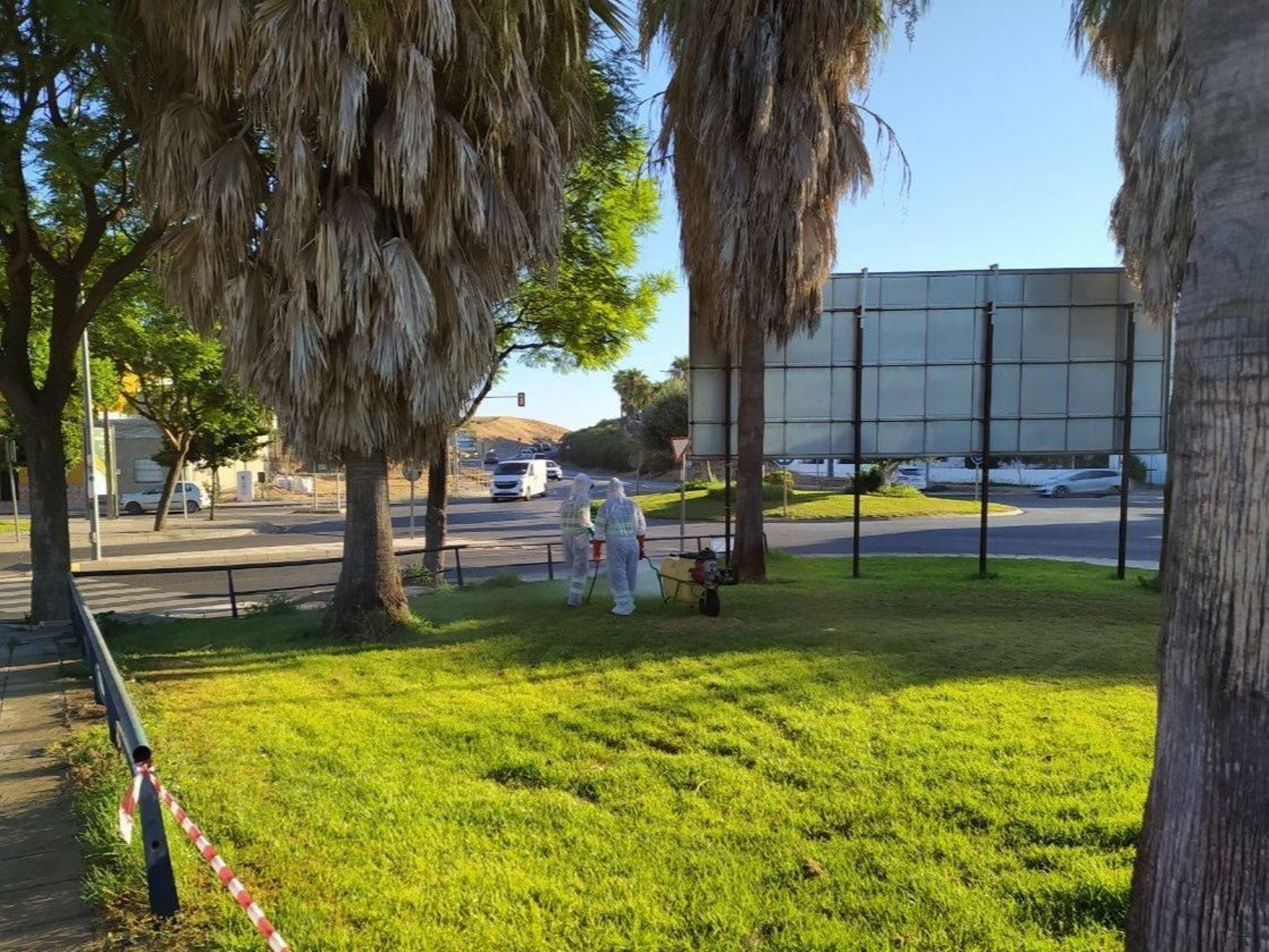 Dos operarios fumigan una zona verde en Coria, el pasado lunes.