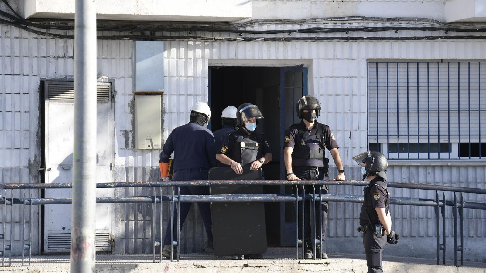 Operarios de Endesa entran en un bloque escoltados por la Policía Nacional.
