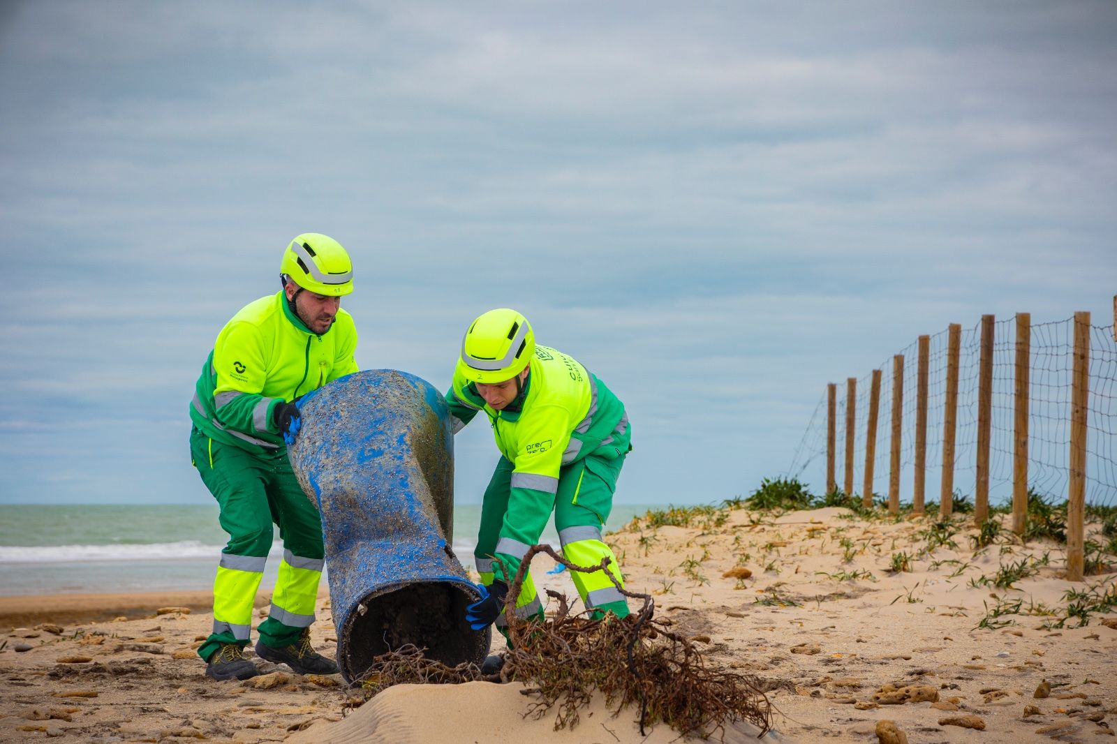 Operarios de los servicios de limpieza retirando residuos de la playa de Camposoto, en San Fernando, tras los temporales
