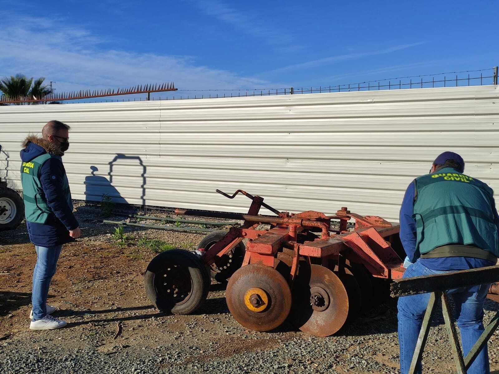 Guardias civiles, con la pieza del tractor recuperada.