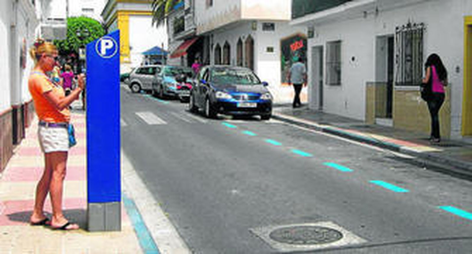 Una conductora saca el tique de aparcamiento en una calle con muchas plazas libres.