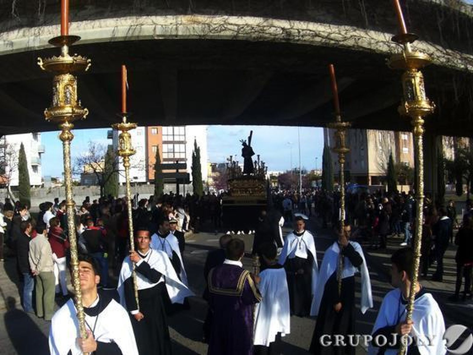 El Señor del Amparo se dirige a pasar bajo el puente elevado del ferrocarril ante numeroso público.  Foto: Manu Garcia