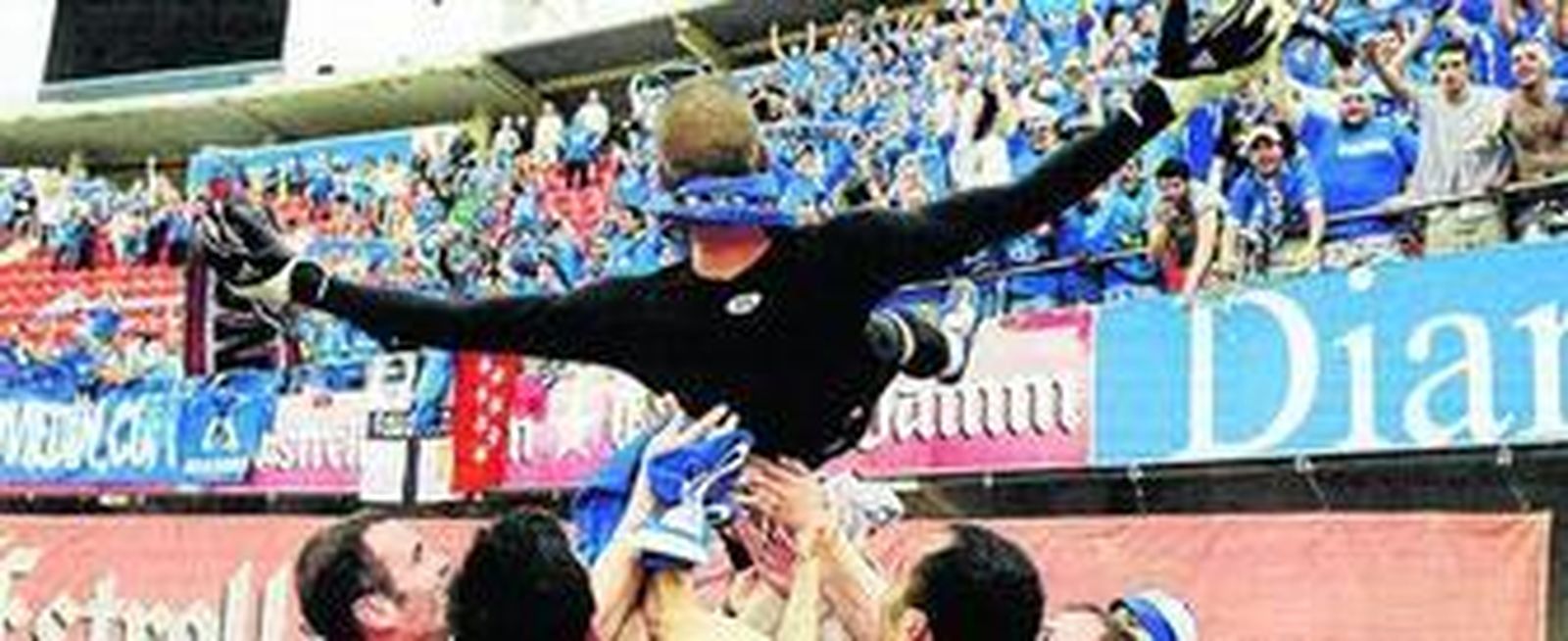 Aulestia abre los brazos mientras es manteado por sus compañeros ante el delirio de la afición del Oviedo por el ascenso obtenido en la temporada 2008-09.