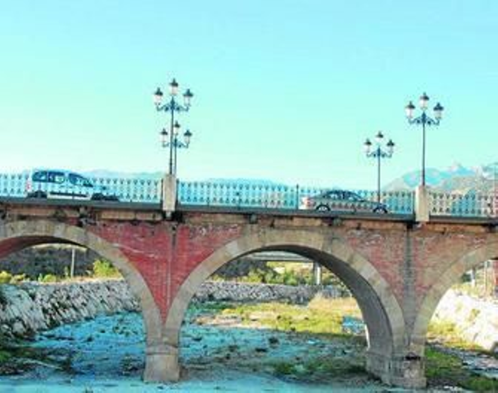 Varios vehículos pasan sobre el Puente Viejo, en Nerja.