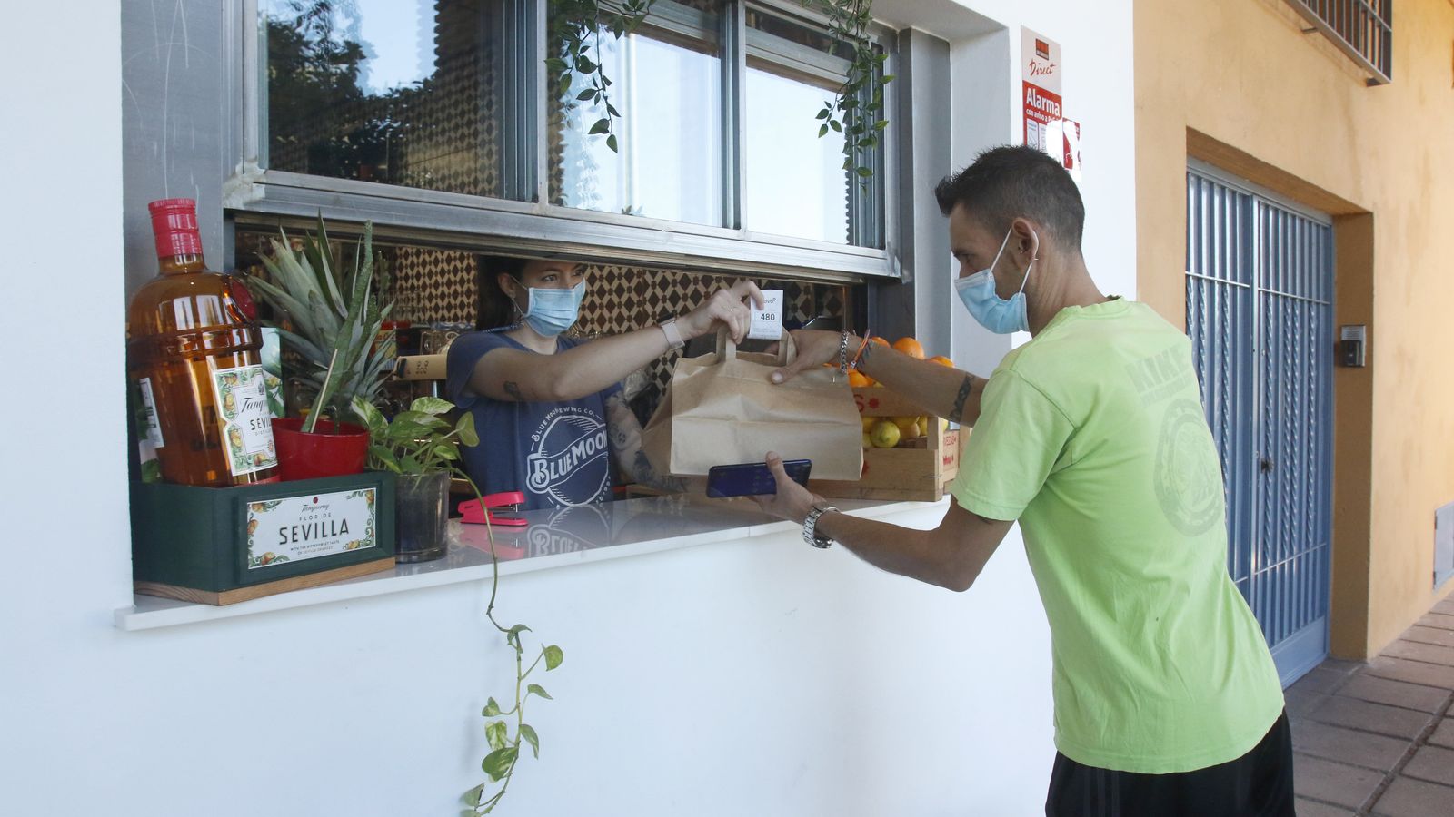 Una camarera entrega un pedido a un repartidor