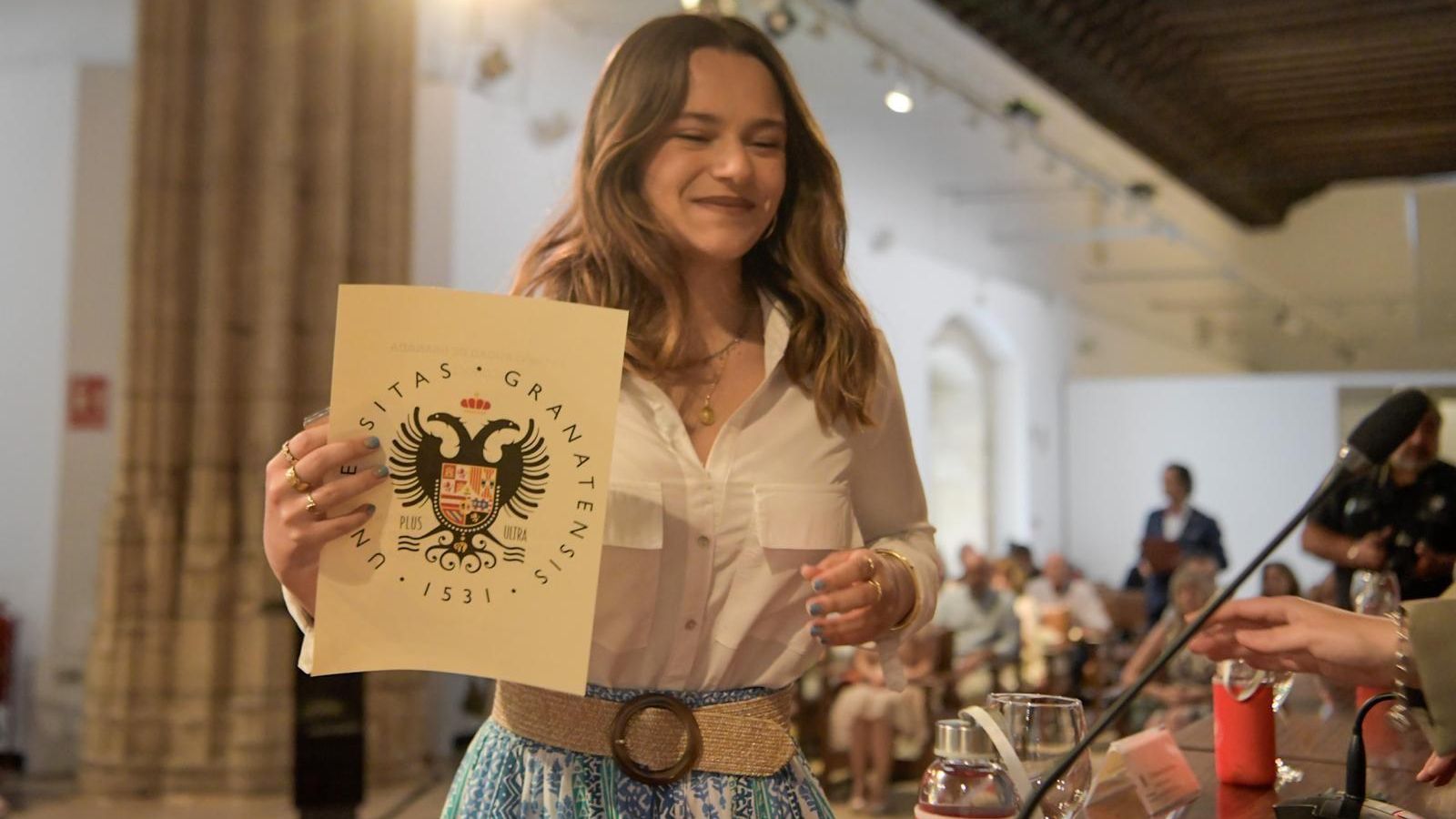 Una de las estudiantes, sonríe tras recoger el reconocimiento.