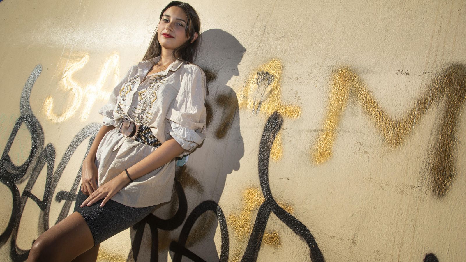 Sae con un grafiti de fondo.