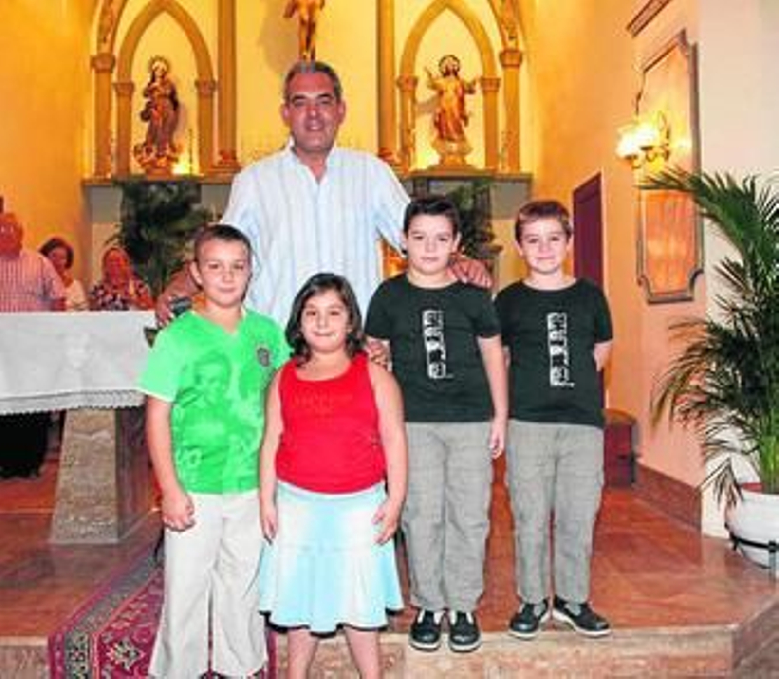 Santiago Martínez, prior de la Comunidad, rodeado de niños en la iglesia de Santa Fe de Mondújar.