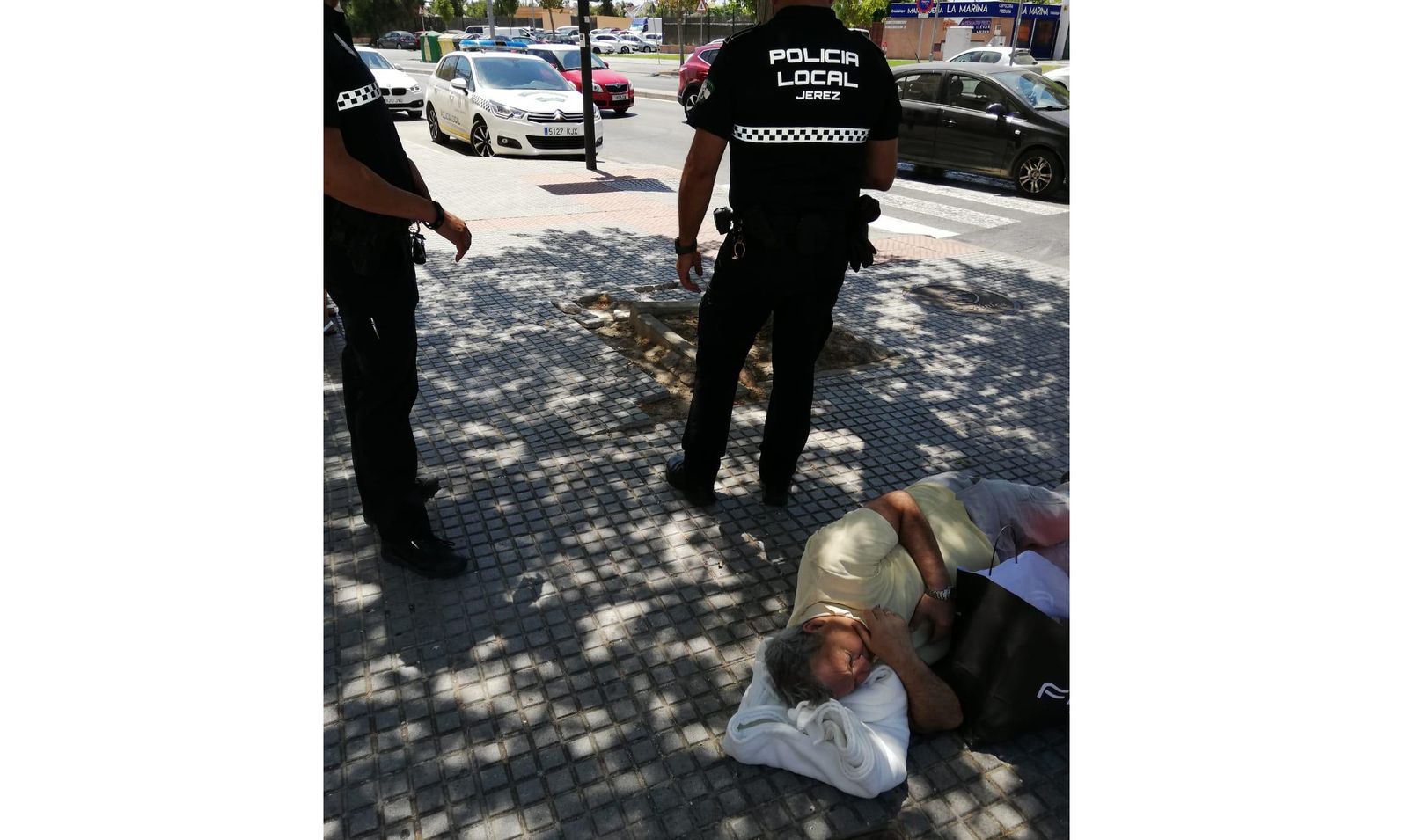 El hombre tumbado en la acera, esperando la ambulancia.