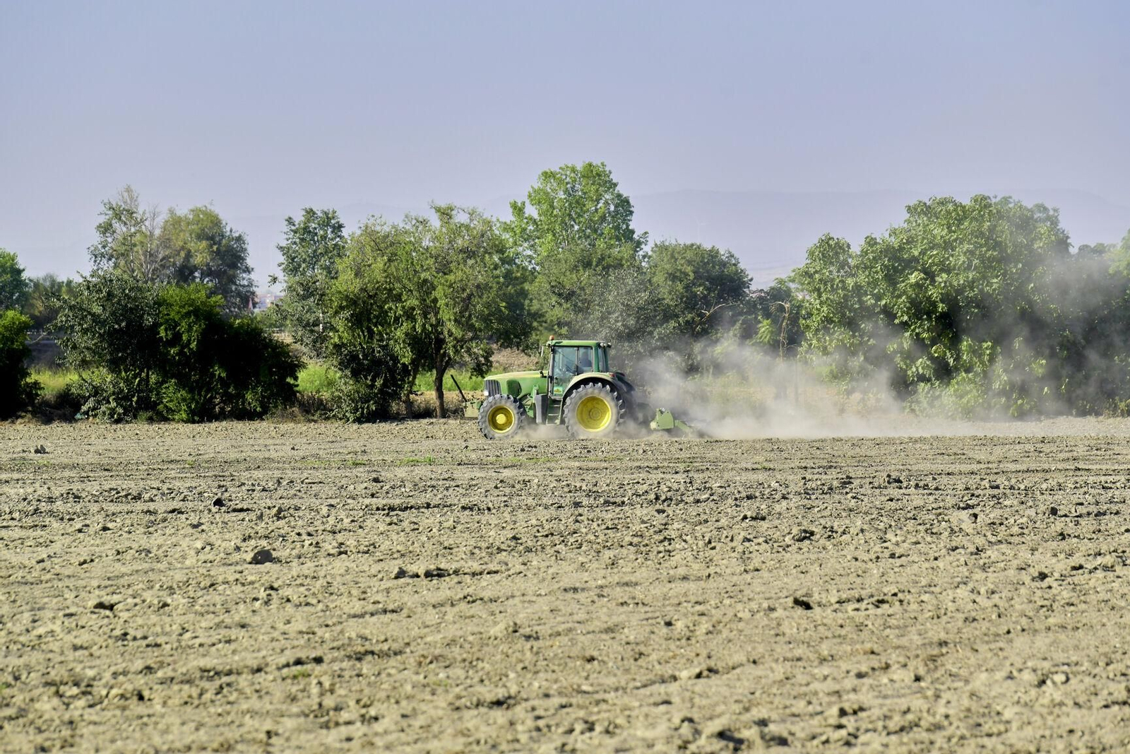 Un agricultor utiliza un tractor en un campo de cultivo cerca de Granada.